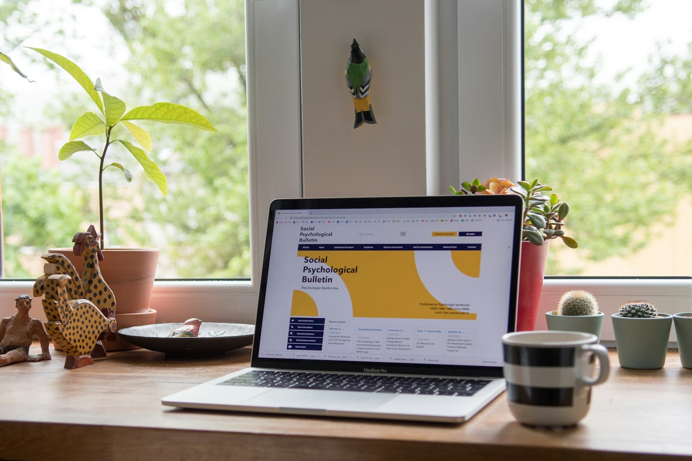 Website on a laptop beside a plant