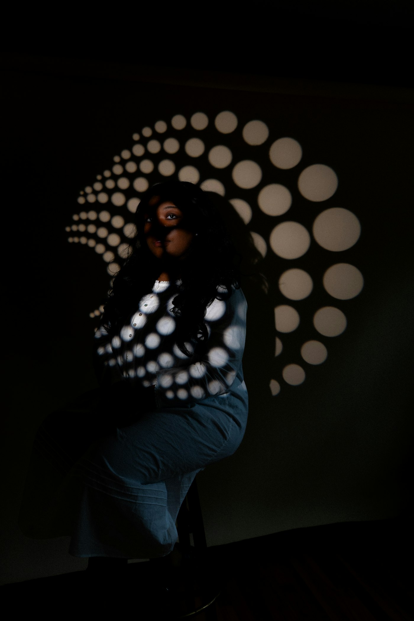 A person lit by a projected pattern of dots